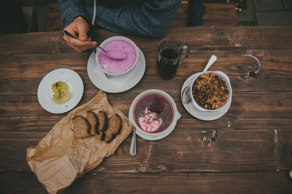 bowl of pink soup with bread and side dishes