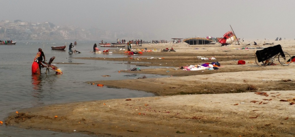 locals along the sandy shores of the Ganges river in Varanasi