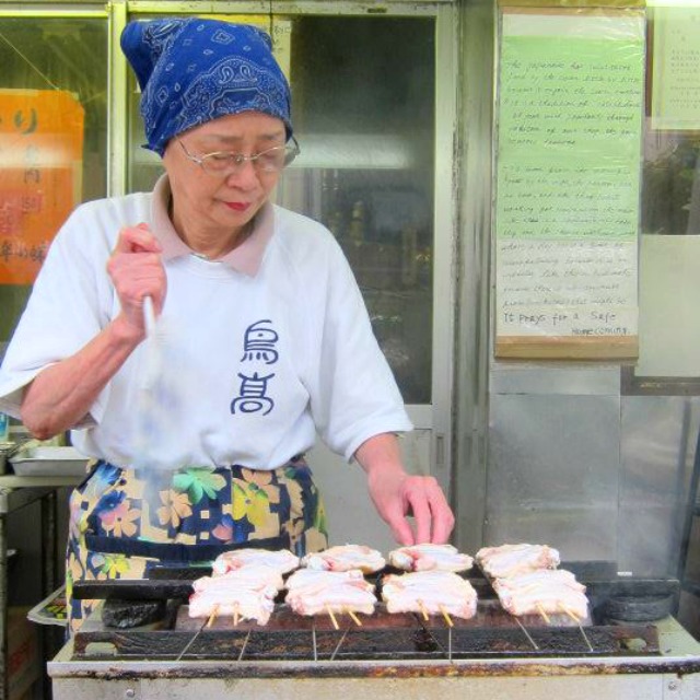 woman grilling yakitori in japan