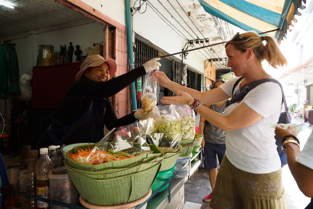 woman selling a bag of takeaway fruit salad